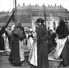 Fish women at Fish Quay with baskets of herring.
