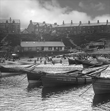 Cullercoats Bay with coble fishing boats and people on the beach.