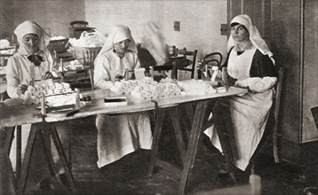 Women volunteers making hospital requisites for the St. John Ambulance Brigade hospital during WWI.