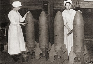 Women putting a coat of paint on aerial bombs during WWI.