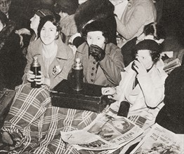 Three women have an early morning cup of tea in Piccadilly Circus.