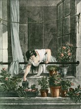 Young woman watering plants on her balcony.