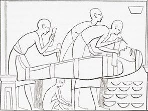 Ancient Egyptians painting the Cartonage or outer case of a mummy.