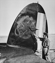 Collaboration between vichy and axis powers, the tail of a German aircraft damaged at Palmyra with Vichy markings painted over with the nazi Swastika.