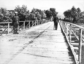 Two soldiers guard bridge during WW1.