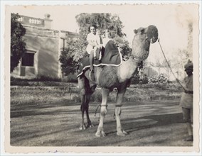 Woman and two children on camel during railway outing