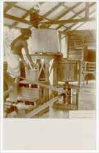 Rubber factory worker with bucket and machine equipment