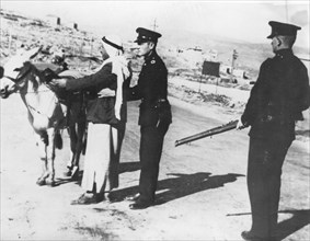 British police officers search an Arab coming from Syria on the Palestinian border