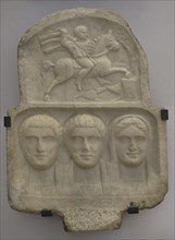 Family group: busts of two bearded men and a woman. Above: relief depicting Heros, the Thracian