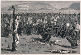 Ernest Grandier, a Zulu prisoner, stands naked and tied to a stake in front of the tribe and awaits