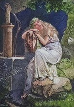 Young woman sitting daydreaming by the fountain in the garden.