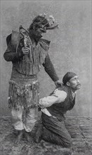 Shaman holding a man on his knees, 1890, Alaska, Historic, digitally restored reproduction from an