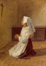 woman prays on her knees in front of a cross on the wall