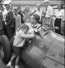 Emmanuel de Graffenried and son Leo in racing car, 1950.