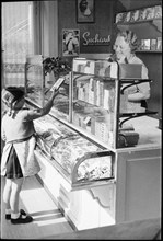 Girl buying chocolate; around 1943.