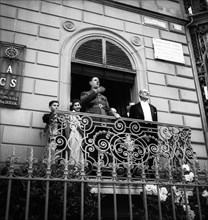 General Charles de Gaulle on a balcony waving to the crowd in Geneva, 1946 .