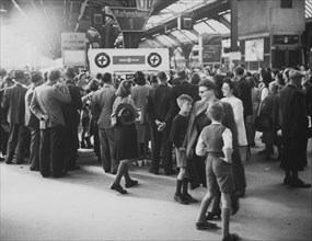 People gather around a stand of Swiss Aid after the war around 1945.