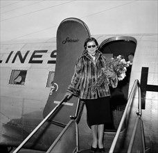 Lys Assia, holding a bouquet.