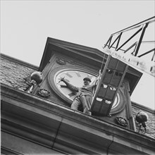 Blackout: man painting numerals of church clock with luminous paint, ca. 1943.