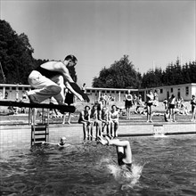 Swimming instructor and girl on the diving platform in circa 1950.