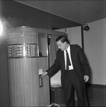 Man waiting for his pictures at a photo booth, Geneva 1959 .