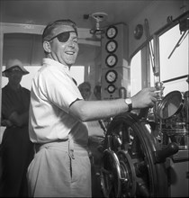 British war invalid at the helm of a tourist boat in Weggis, 1948