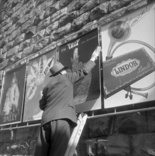 Poster advertising, man placarding, aound 1950