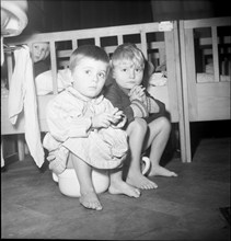 Children sitting on potty, around 1960.