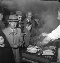 Zurich Festival 1953; sausage on the grill at a stand.