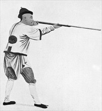 This illustration of a Chinese soldier, holding and aiming his gun, dates to 1900. The time period