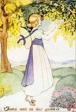 The 1917 caption reads: “Bending down a branch of the Laburnum tree- Queen of the May - Story -