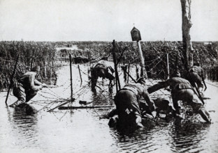 This photo dates to the First World War. The caption reads: Americans cutting wire entaglements