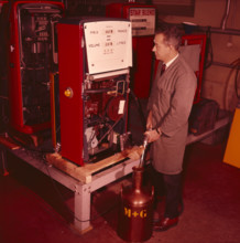 Testing of a petrol pump, gas pump, technician filling a container 1965.