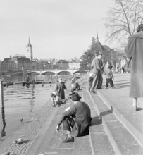 People strolling along the Limmat river.