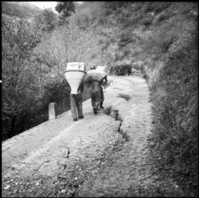 Landslide in the Misox valley, men carrying goods to supply the population; 1960.