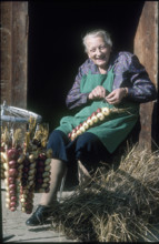 Emma Spahni weaving strings of onions 1982.