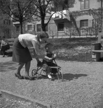 Mother and daughter playing outdoors, Switzerland 1940.