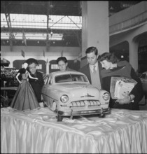 Visitors admire exhibited model car.