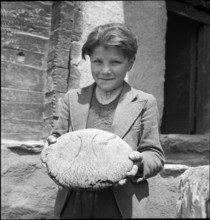 Boy with freshly baked bread in St. Luc, Valais, in 1941.
