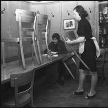 Closing time; Waitress putting chairs on tables 1969.