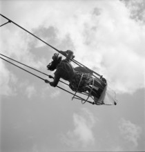 Primary school party in the woods; girl on swing boat 1945.