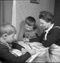Mother helping their sons doing their exercises, 1941.