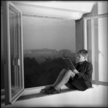 Male Teenager Reading in Community Home.