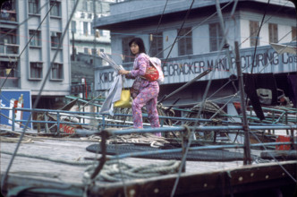Woman with child taking down laundry, Macau 1979.