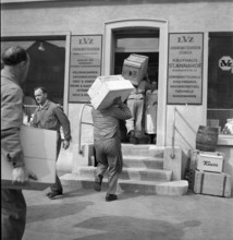 Storekeepers carry goods into the department store St. Annahof in Zurich, 1941.