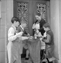 W K 2: war economics; young people collecting material to be recycled.