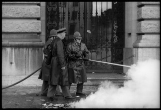 Policemen put fire out, burning civil defence book.