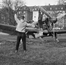 Boys playing on old Messerschmitt fighter plane.