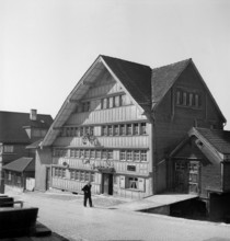 Herisau; Old man walking in a street; 1945.
