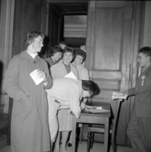 Young women signing entry on list, women.